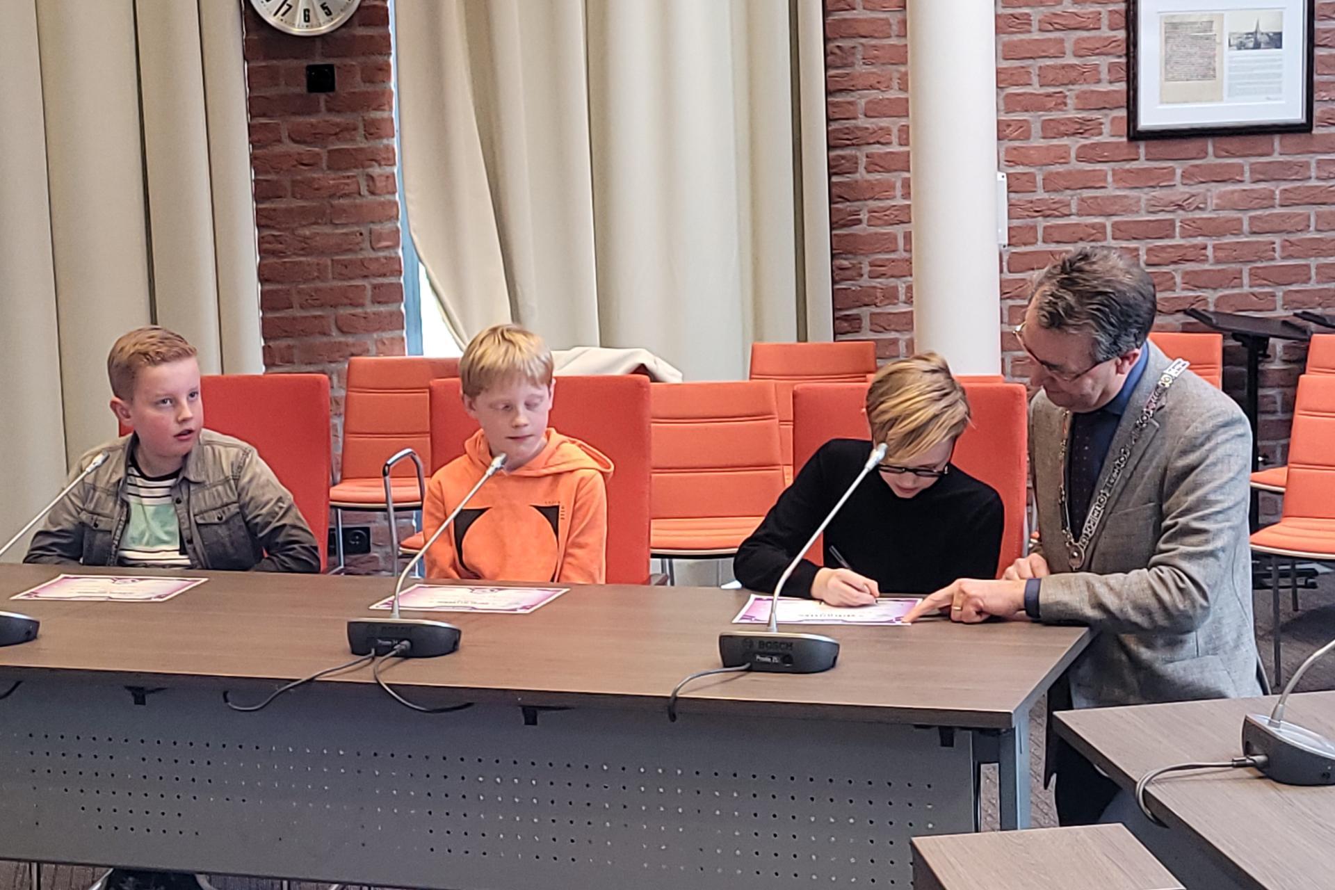 Burgemeester Jan Pierik tekent certificaten met de drie beste Cyber Agents van gemeente Borne
